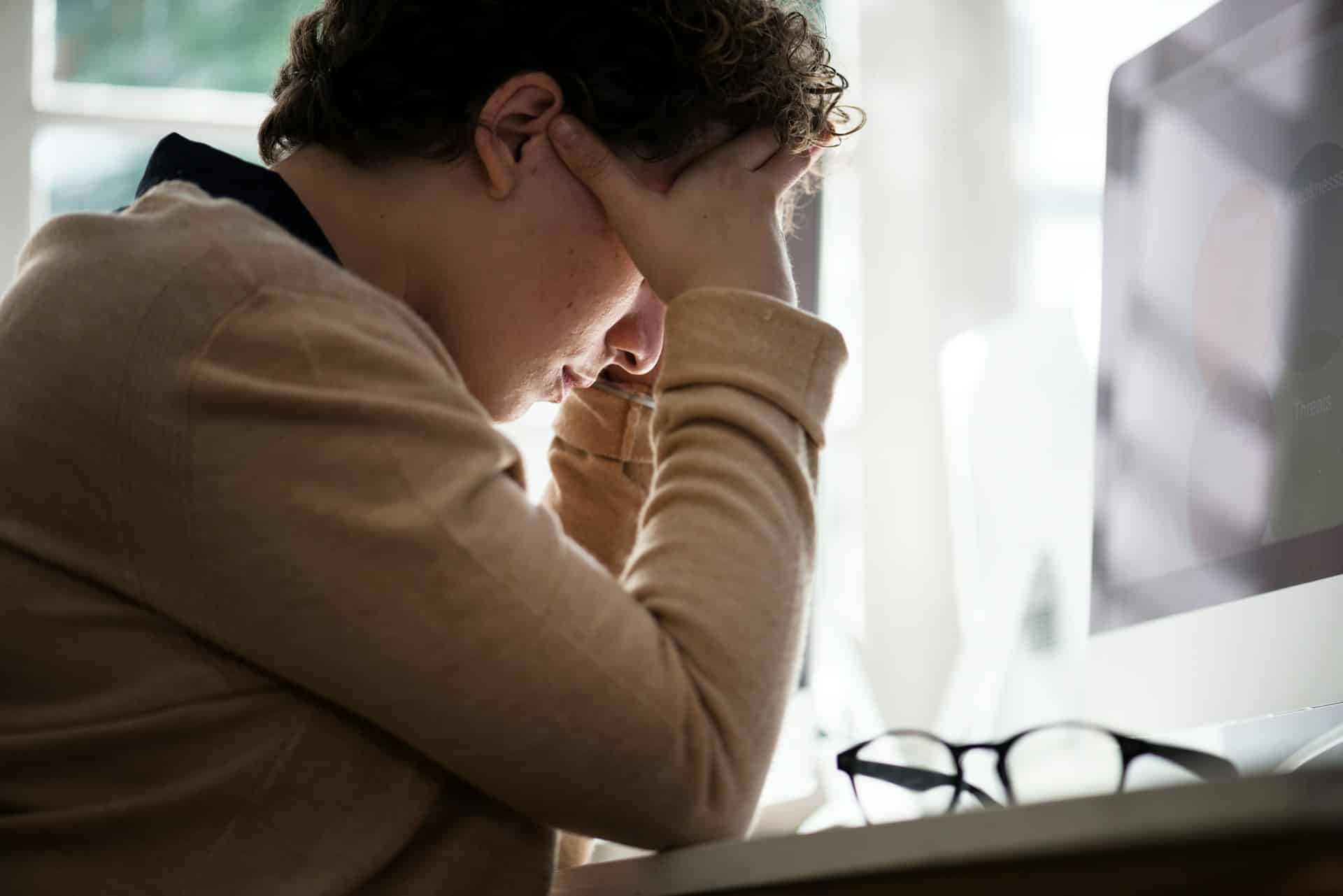 a person holding their head in their hands