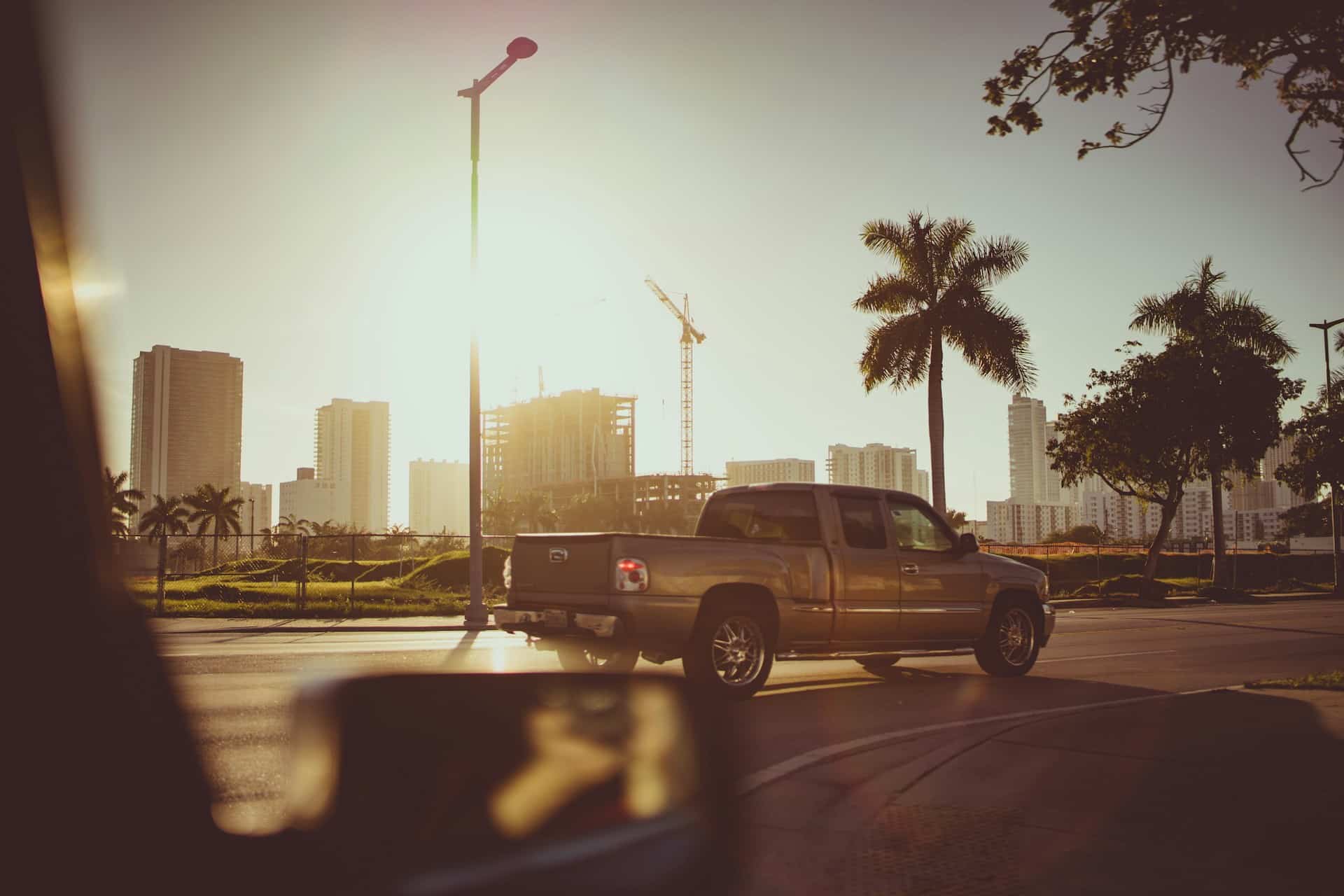 a truck driving on road with palm trees