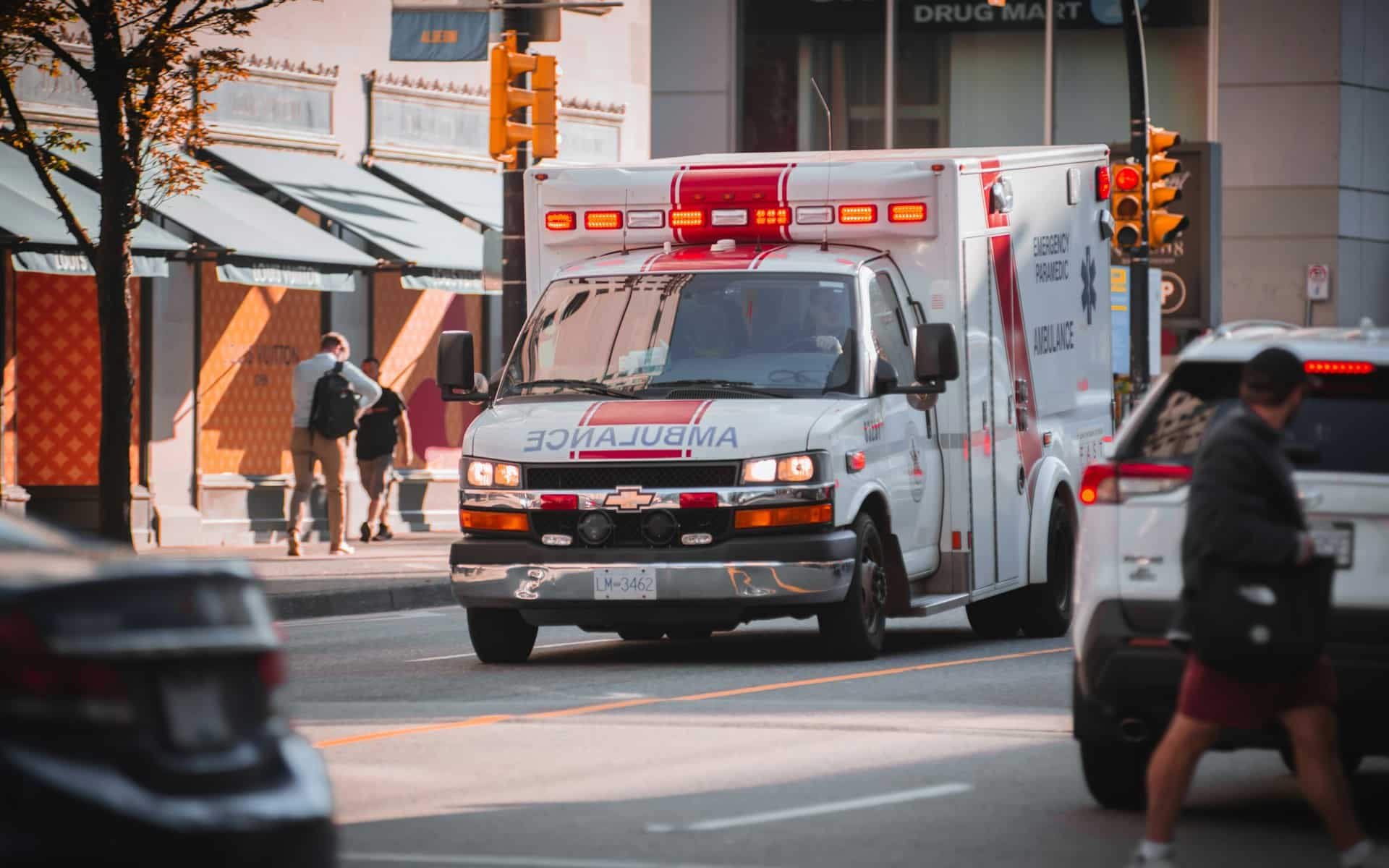 an ambulance driving down a busy city street